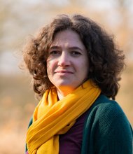 Grüne Fraktionärin Leonie Engelbert, vor unscharfer gelblicher Vegetation