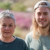 Grüne Fraktionsvorsitzende Suse Stobbe und Julian Schlumberger, vor unscharfer, rötlich-gelber Vegetation
